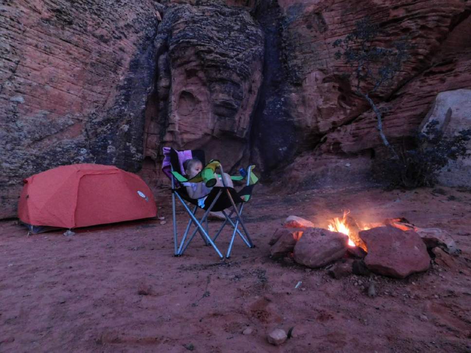 Erin Alberty  |  The Salt Lake Tribune 

A young camper sits by the fire at Sand Cove Primitive Campground on April 1, 2017 in the Red Cliffs Desert Reserve near Leeds.