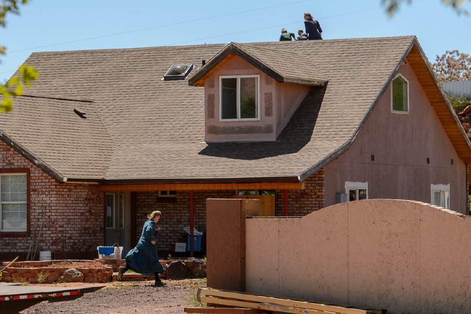 Trent Nelson  |  The Salt Lake Tribune
An FLDS woman runs away and another scurries her children off the roof as Mohave County Constable Mike Hoggard arrives to post a second eviction notice on a Colorado City, AZ, home, Monday May 1, 2017.