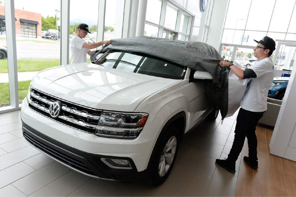 Francisco Kjolseth | The Salt Lake Tribune
Detailers Cody Combs, left, and Adnan Uzeirbegovic uncover one of the first Atlas, V6 4motion vehicles in the brand new Volkswagen showroom on Main street in Salt Lake City on May 18, 2017.