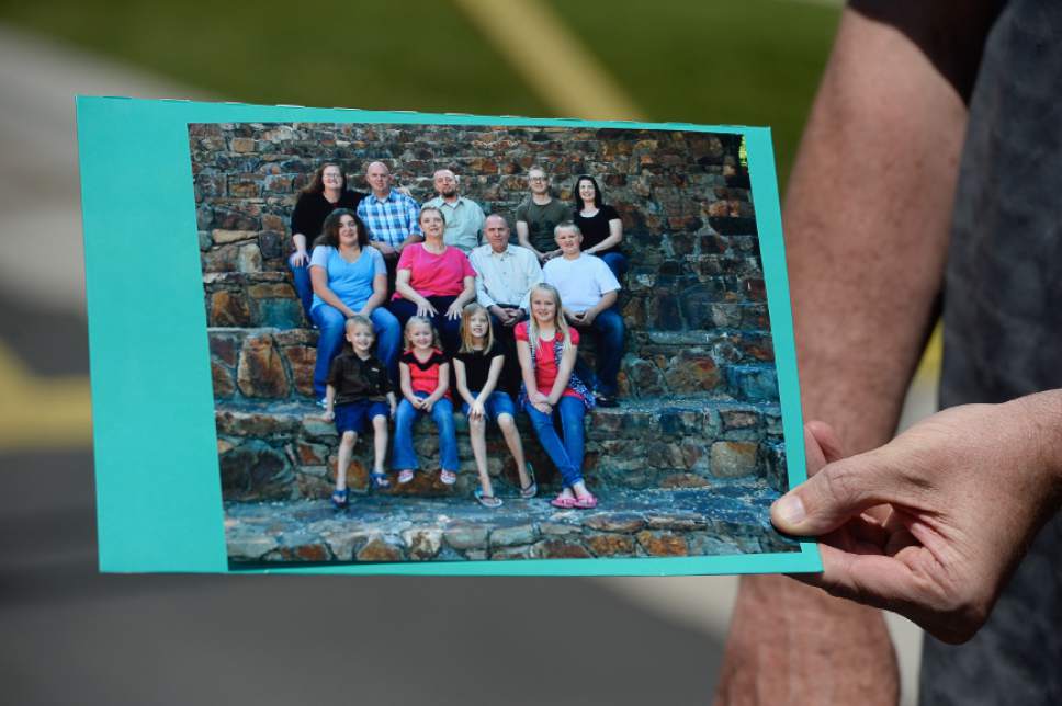 Francisco Kjolseth | The Salt Lake Tribune
Richard Massey, a family spokesperson for missing UTA worker 63-year-old Kay Porter Ricks, holds up a family photograph of Kay, center right, with his family. Kay's body who was found Tuesday in Wyoming.