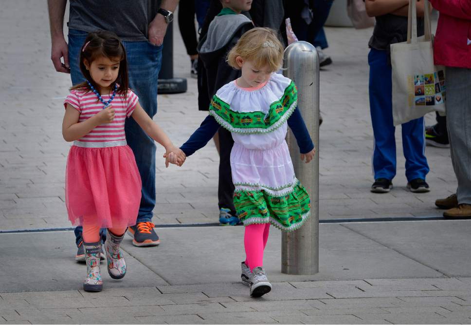 Scott Sommerdorf | The Salt Lake Tribune
Two little girls cross hand in hand from Library Square at the 32nd Living Traditions Festival at Library Square on Sunday.