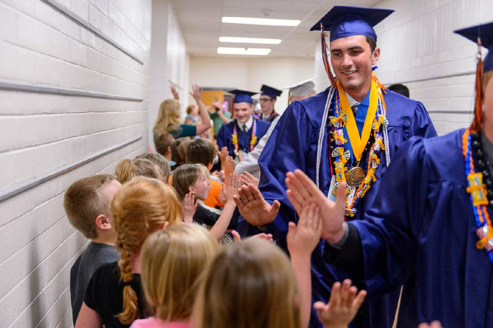 Trent Nelson  |  The Salt Lake Tribune
Water Canyon High School graduate Roy Jessop walks a procession of high-fives through Water Canyon Elementary prior to the high school's graduation ceremony in Hildale, Monday May 22, 2017. Two years ago the school had one graduate, this year twenty-five.