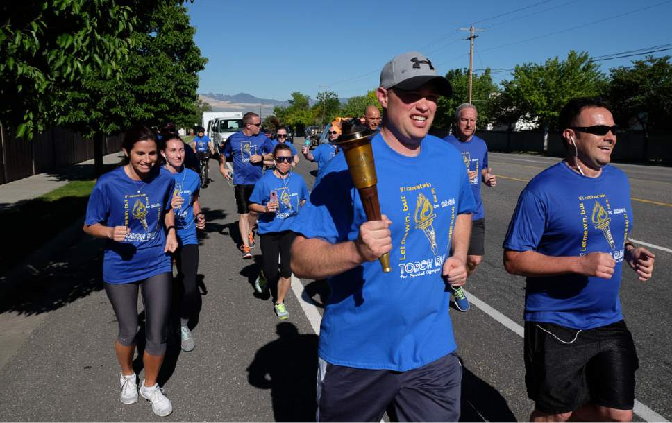 Francisco Kjolseth | The Salt Lake Tribune
Officers Jordan Upchurch, center, and Rulon Green, right, of the Draper Police Department participate in the annual Law Enforcement Torch Run for Special Olympics Utah by carrying the "Flame of Hope" from 11400 South State Street to Draper City Hall on Wed. May 24, 2017.