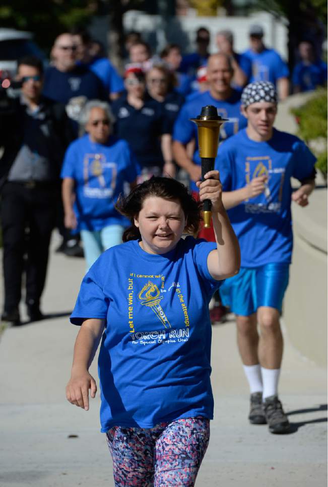 Francisco Kjolseth | The Salt Lake Tribune
Amilia Rutledge is cheered on for the final leg of the Torch Run for Special Olympics Utah by carrying the "Flame of Hope" to Draper City Hall on Wed. May 24, 2017.