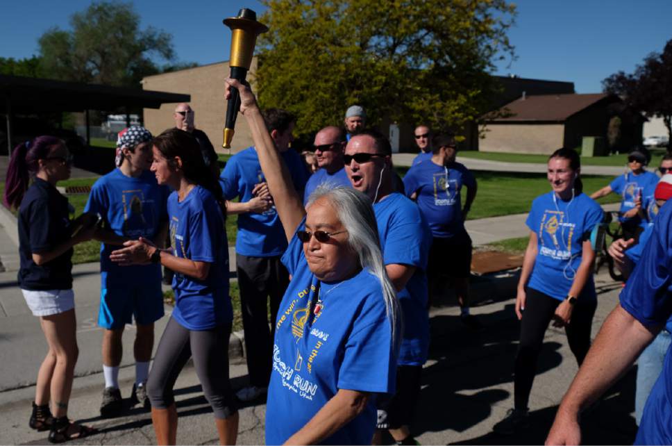 Francisco Kjolseth | The Salt Lake Tribune
Special Olympic athlete Daisy Whitehorse holds the "Flame of Hope" up high during the final moments of the torch run before arriving at Draper City Hall on Wed. May 24, 2017.