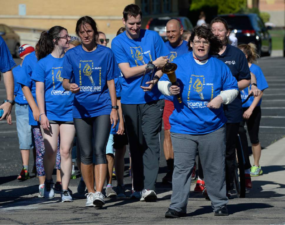 Francisco Kjolseth | The Salt Lake Tribune
Athlete Rachel Eager takes a turn carrying the Special Olympics torch as she is joined by other athletes and members of the Draper Police Department for the annual Law Enforcement Torch Run for Special Olympics Utah by carrying the "Flame of Hope" from 11400 South State Street to Draper City Hall on Wed. May 24, 2017.