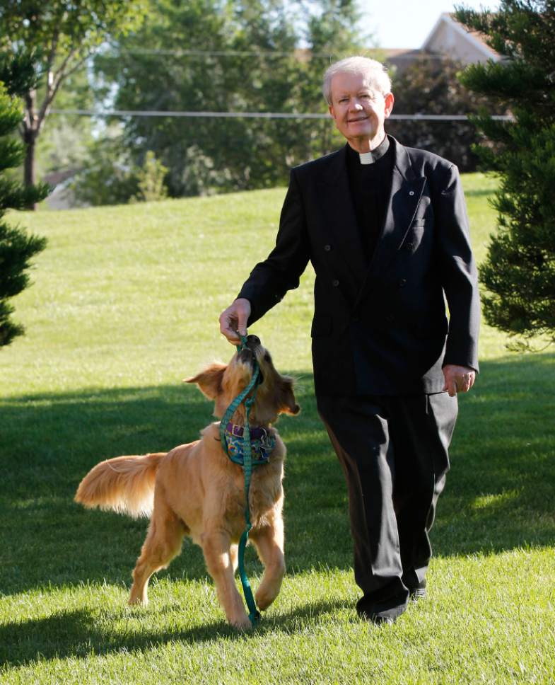 Al Hartmann  |  The Salt Lake Tribune

Monsignor Terence Moore plays with his dog Bailey on a walk.