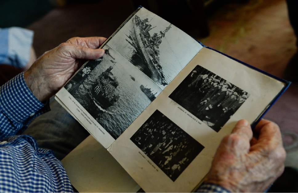 Francisco Kjolseth | The Salt Lake Tribune
Salt Lake City resident and WWII Navy vet Clayton James "Jim" Kearl, 96, overlooks a small book he received after the war that serves as a historical record aboard the USS Salt Lake City. The heavy cruiser ship had 1,200 men aboard and was involved in more engagements than any other ships during the war.