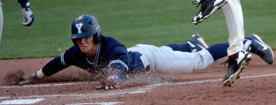 Steve Griffin  |  The Salt Lake Tribune
BYU's Brennon Anderson slides safely into home after a wild pitch from Utah's Chase Bauerle during game at Smith's Ballpark in Salt Lake City Tuesday March 28, 2017.