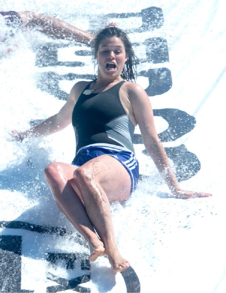 Rick Egan  |  The Salt Lake Tribune

Josie Dalley, cools off by sliding down a home made slipping' slide with water pumped from a stream, at Rock Canyon Park, Monday, May 29, 2017.