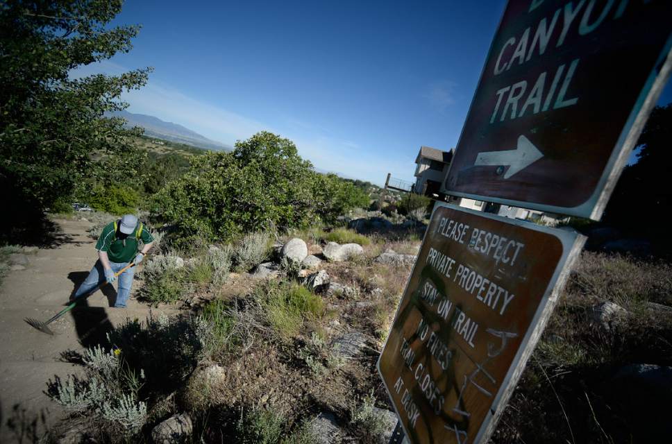 Scott Sommerdorf | The Salt Lake Tribune
Volunteers worked near a graffito on one of the signs along the Bells Canyon Trail, Saturday, June 3, 2017. Sandy municipal employees performed maintenance and installed improvements on the trail on National Trails Day.