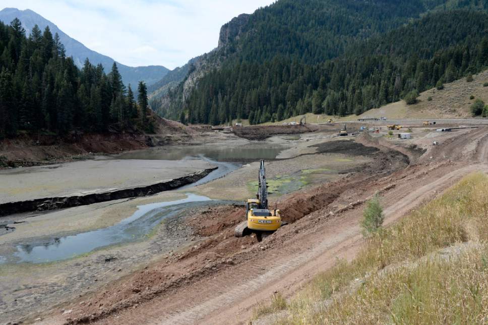 Al Hartmann  |  Tribune file photo
Backhoes dug a trench around the side of Tibble Fork Reservoir in August 2016, enabling the incoming flow of water in the upper part of the reservoir to be diverted so crews could remove toxic sediment.