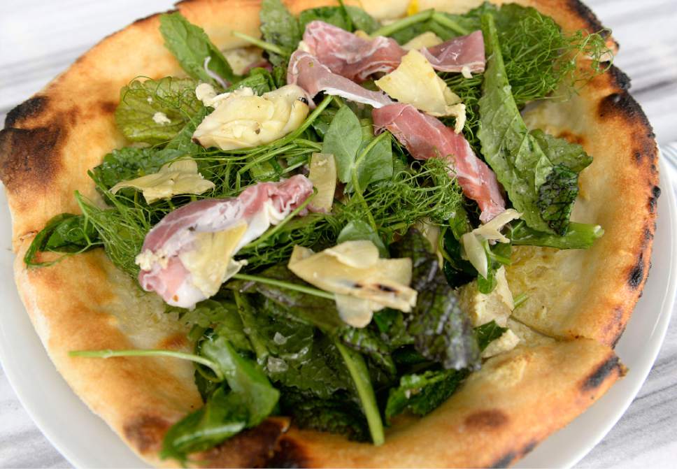Al Hartmann  |  The Salt Lake Tribune 
Baldy Pizza made with garlic oil, valle d'aosta fontina, artichoke, parma prosciutto, farm eggs and baby greens   from the wood fired pizza oven at Fireside on Regent. It's attached to the new Eccles Theatre and is the first of several planned restaurants on historic Regent street.