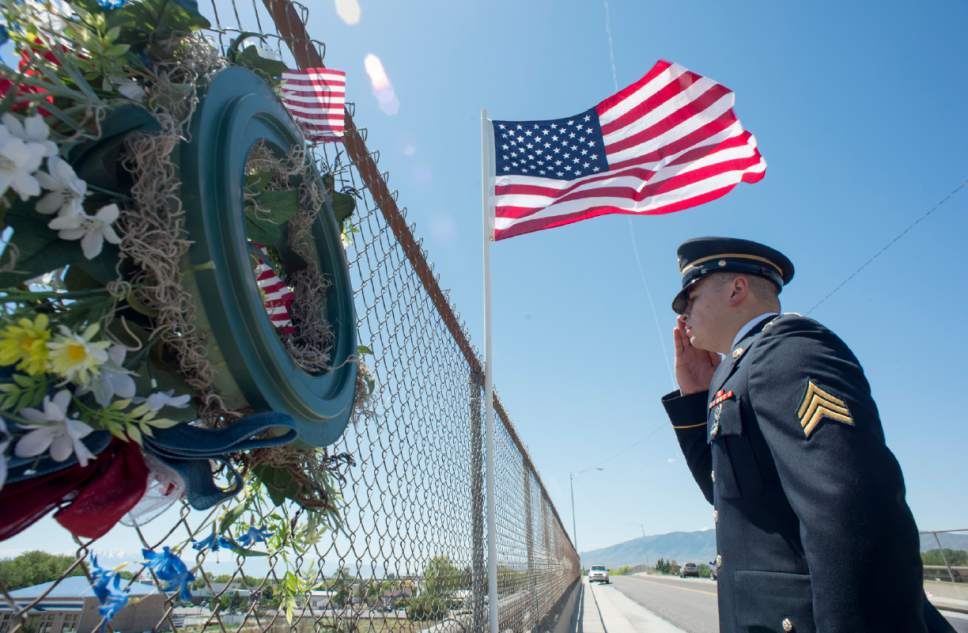 Rick Egan  |  The Salt Lake Tribune

Ross Grenko salutes cars on I-15, as he stands on an overpass on Memorial Day in Lehi, Monday, May 29, 2017.