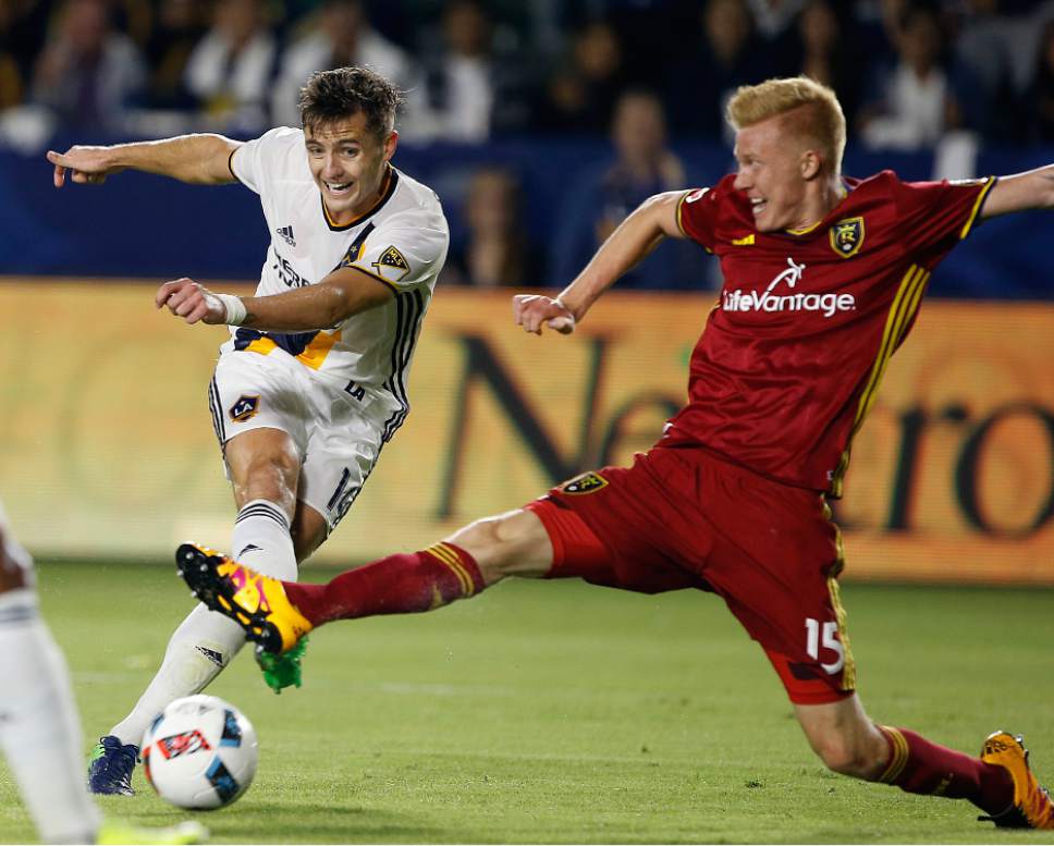 Real Salt Lake defender Justen Glad, right, stops a shot by Los Angeles Galaxy forward Robbie Rogers, left, during the second half of a knockout round MLS playoff soccer match in Carson, Calif., Wednesday, Oct. 26, 2016. Galaxy won 3-1. (AP Photo/Alex Gallardo)