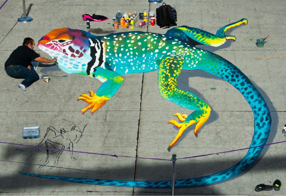 Rick Egan  |  The Salt Lake Tribune

Feature artist Julie Kirk Purcell works on her 3-D lizard creation on Rio Grande Street at the Gateway, during the Utah Foster Care Chalk Art Festival, Saturday, June 17, 2017.