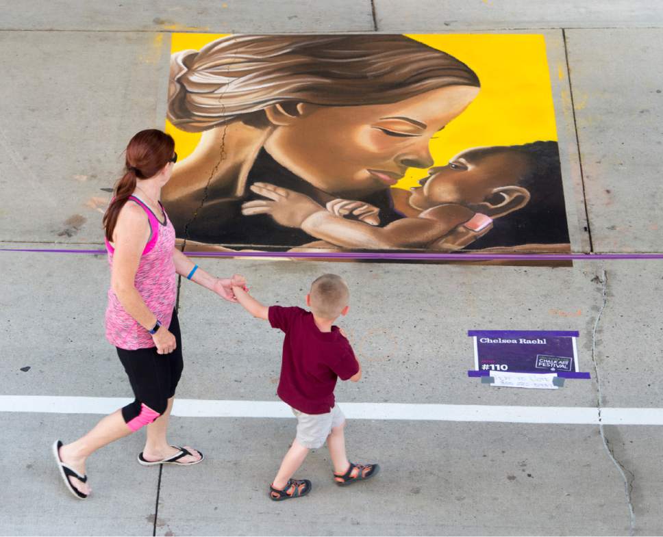 Rick Egan  |  The Salt Lake Tribune

Pedestrians check out the chalk art drawing by Chelsea Raehl on Rio Grande Street at the Gateway, during the Utah Foster Care Chalk Art Festival, Saturday, June 17, 2017.