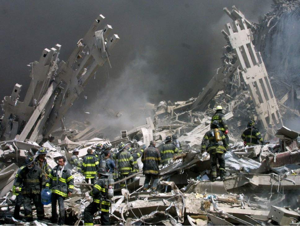 FILE - In this Sept. 11, 2001 file photo, firefighters make their way through the rubble after two airliners crashed into the World Trade Center in New York bringing down the landmark buildings. The White House lashed out at Congress on Thursday, Sept. 29, 2016, a day after Republicans and Democrats overwhelmingly overrode President Barack Obama's veto of a bill to allow families of the 9/11 victims to sue Saudi Arabia. The White House turned to mockery as top GOP leaders expressed buyer's remorse and vowed to fix the bill. (AP Photo/Shawn Baldwin/File)