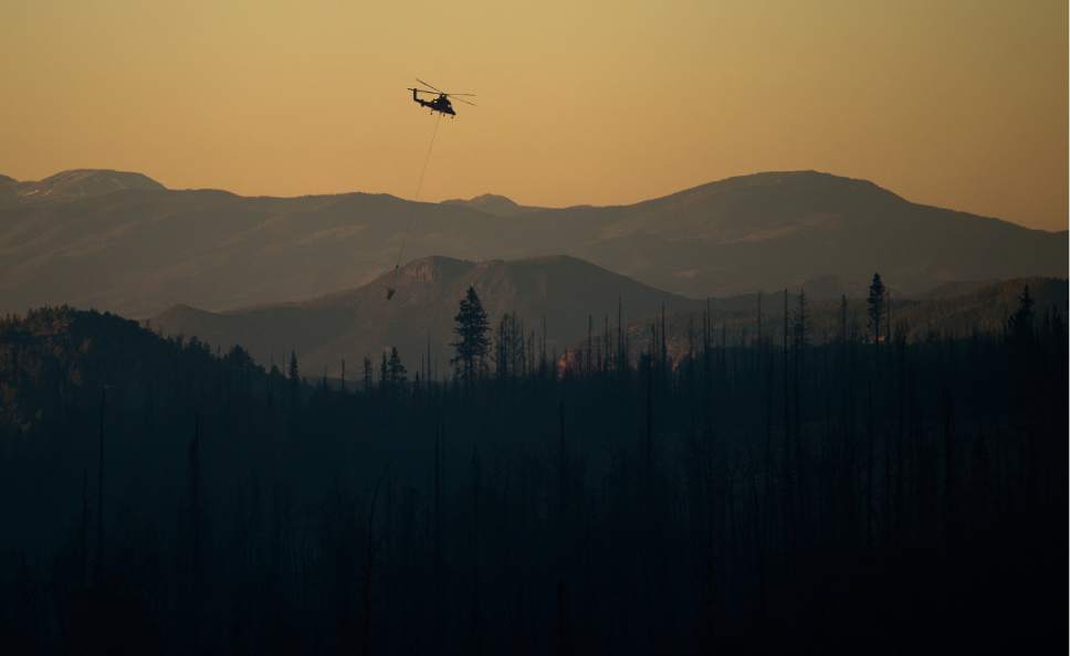 Leah Hogsten  |  The Salt Lake Tribune
Helicopter crews put out hot spots as night falls Sunday, June 18, 2017, while working a wildfire burning north of the southern Utah ski town of Brian Head.