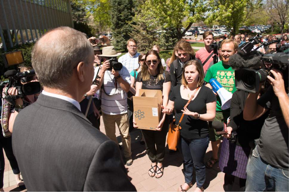 Leah Hogsten  |  The Salt Lake Tribune
Care2 petition campaign writer Kelsey Bourgeois talks briefly with BYU's Academic Vice President Brent Webb, who accepted the signatures.  Care2 petition supporters delivered 60,000  petition signatures to Brigham Young University's Abraham O. Smoot administration building, Wednesday, April 20, 2016 to protest the school's ìHonor Codeî and to ask the school to add an immunity clause shielding sexual assault victims from Honor Code investigations.