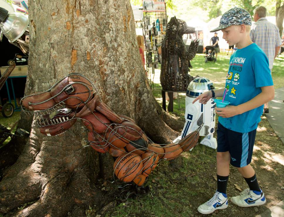 Leah Hogsten  |  The Salt Lake Tribune
Carter Watson, 11, marvels at the metal T-Rex dinosaur by artist Bradley Anderson of Bozeman, MT at the Utah Arts Festival on Friday. The Utah Arts Festival is the largest outdoor multi-disciplinary arts event in the state, running through Sunday June 25, 2017 at the City and County Building grounds in downtown Salt Lake City.
