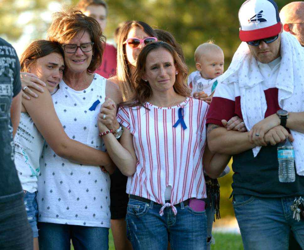 Leah Hogsten  |  The Salt Lake Tribune
From left: Jill Lloyd's niece Gabby Beckstrom, mother Paula Densley, sister Macey Smith and brother-in-law Landon Smith weep as family members recount loving stories of Jill. Family, friends and loved ones gather at a vigil for Jill Lloyd, 36, to tell stories and share their love for the woman who was killed by her son's father. Lloyd was driving in West Jordan on Wednesday when 33-year-old Andrew Jed Larsen shot her multiple times, police said.
Larsen, with whom Lloyd had a child 11 years ago, later shot and killed himself in Tooele County, police said