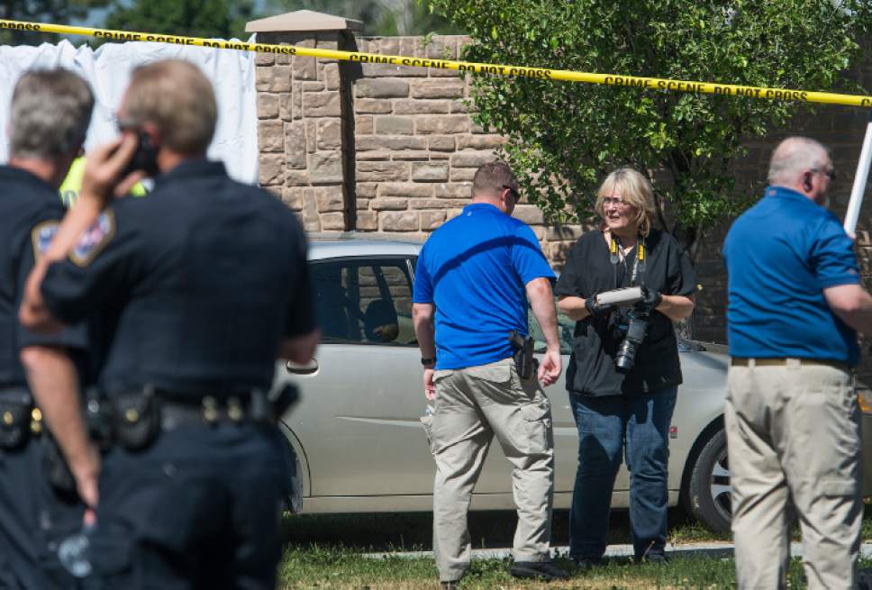 Leah Hogsten  |  The Salt Lake Tribune
West Jordan Police investigator and photographer removes the victim's purse from her car at the scene where a woman is dead after a drive-by shooting incident in West Jordan on Wednesday morning. West Jordan police Sgt. Joe Monson said the woman, whose identity was not immediately released, was stopped at a stop light at Jaguar Drive (2700 West) and 7800 South, when at least one shot was fired into her car at 8:59 a.m.. Her car crashed into a wall and a tree a short distance later.

Monson confirmed the woman was found dead at the scene.