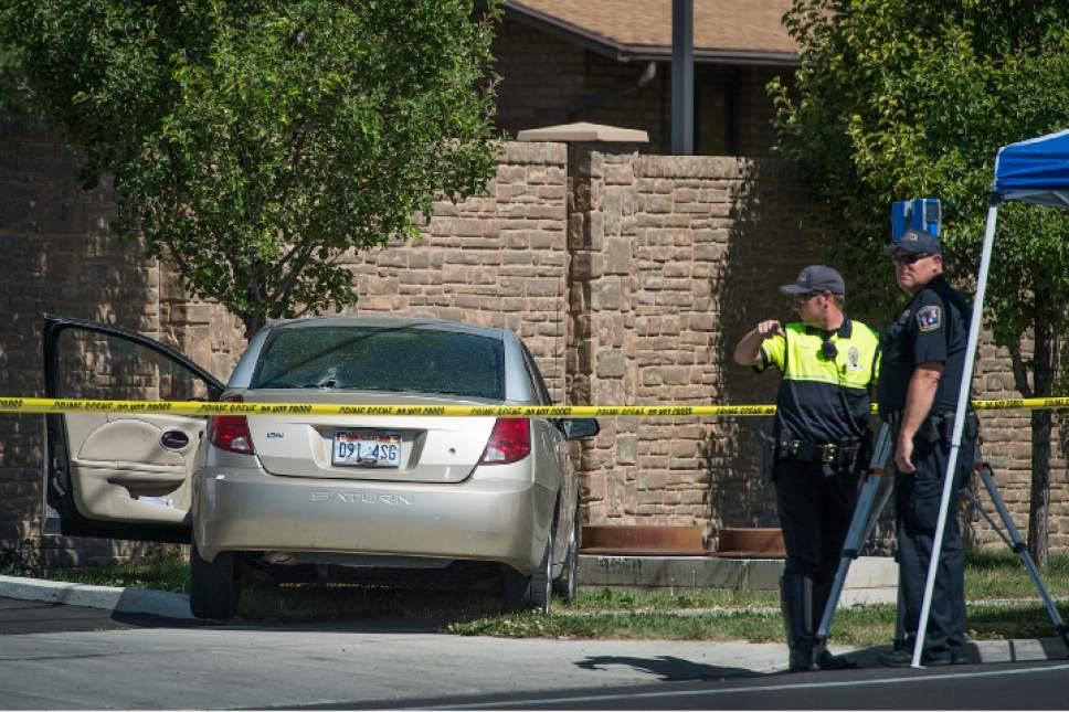 Leah Hogsten  |  The Salt Lake Tribune
West Jordan Police investigate the scene where a woman is dead after a drive-by shooting incident in West Jordan on Wednesday morning at a stop light at Jaguar Drive and 7800 South, when at least one shot was fired into her car which crashed into a wall and a tree a short distance later. The victim's identity was not released.