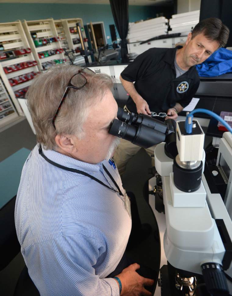 Al Hartmann  |  The Salt Lake Tribune
Salt Lake Tribune columnist Robert Kirby takes a look through a state-of-the-art microscope that analyzes bullet shell casing marks with Crime Lab Director Jay Henry on Thursday.