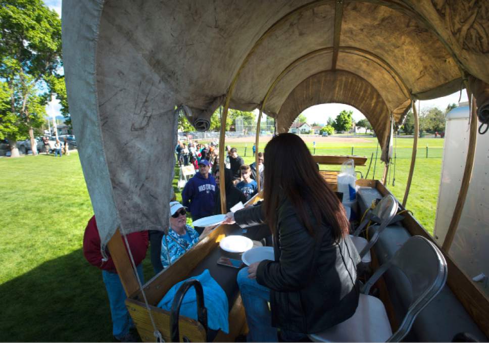 Steve Griffin  |  The Salt Lake Tribune
Citizens line up at the covered wagon to get tickets to the Memorial Day chuck-wagon breakfast at the Herriman City Park on Monday, May 25, 2015.
