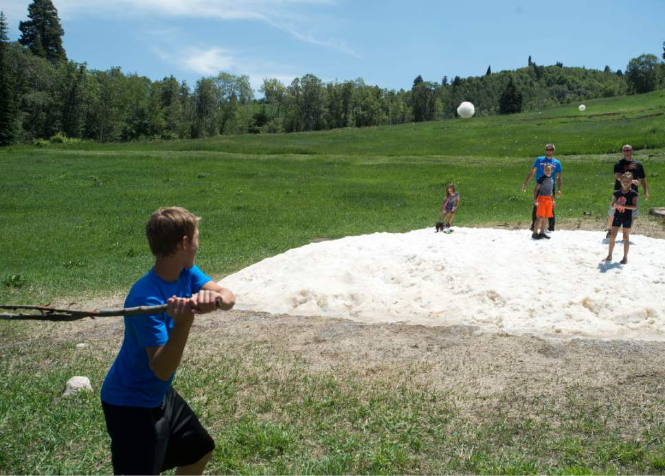 Rick Egan  |  The Salt Lake Tribune

Family members toss snowballs to Ty Kirkland, 14, Mountain Green as the play in a snow bank at Snowbasin Ski resort, Sunday, July 2, 2017.