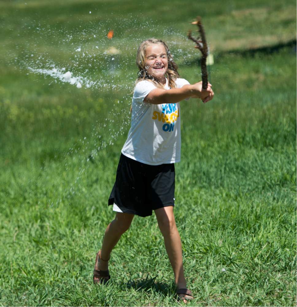 Rick Egan  |  The Salt Lake Tribune

Elena Kirkland, 12, Mountain Green, takes a swing at a snowball with a stick, as she and her family play in a snow bank at Snowbasin Ski resort, Sunday, July 2, 2017.