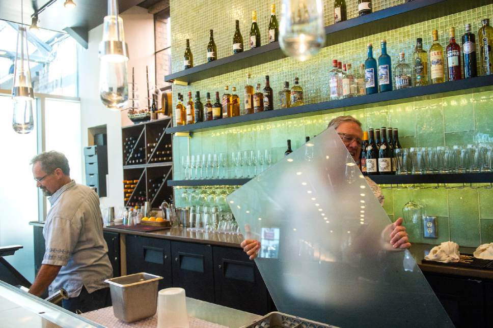 Chris Detrick  |  The Salt Lake Tribune
Owner Joel LaSalle, right, and Building Manager Mark Silvester tear down the Zion Curtain around the restaurant bar at Current Fish & Oyster in Salt Lake City on Saturday, July 1, 2017. A new law goes into effect Saturday,  allowing restaurants options other than the 7-foot opaque barrier intended to block children from seeing drinks being mixed. Restaurants can choose to keep the "Zion Curtain"; create a 10-foot buffer from the bar where minors are not allowed; or build a half-wall or railing, at least 42 inches high, that creates a delineation between the dining and liquor-dispensing areas.