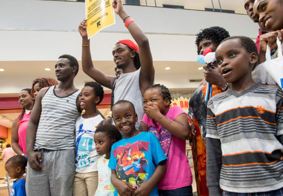 Leah Hogsten  |  The Salt Lake Tribune
l-r Gustav Nyangabo poses with his friend Patient Gatabazi holding a welcoming sign for the arrival of Nygangabo's mother and siblings from the Democratic Republic of Congo, moments after their arrival in Utah where the entire family was reunited. The Salt Lake City office of the International Rescue Committee welcomed the last refugee family to Utah,  July 6, 2017, before President Donald Trump's 120-day ban on refugees goes into effect.