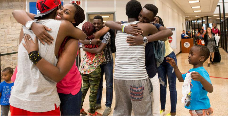 Leah Hogsten  |  The Salt Lake Tribune

l-r Adeline Uwicyeza and her brothers Makuza Innocent, center, and Kayrianga Jules, right, are all smiles receiving hugs after their arrival to Salt Lake City with her mother and two other siblings (pictured walking through security at right) from the Democratic Republic of Congo. The Salt Lake City office of the International Rescue Committee welcomed the last refugee family to Utah on Thursday,  July 6, 2017, before President Donald Trump's 120-day ban on refugees goes into effect.