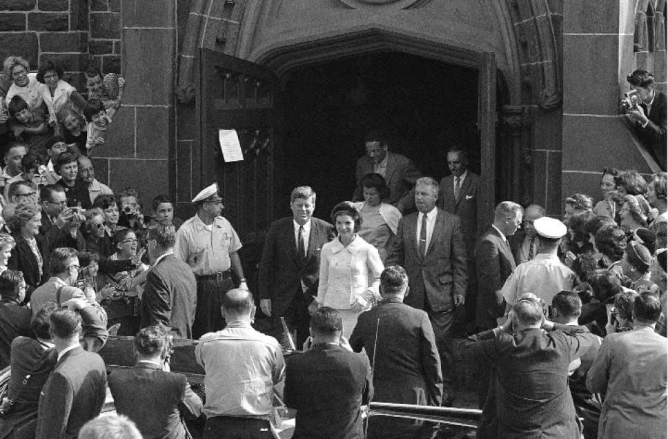 FILE - In this Oct. 1, 1961 file photo, President John F. Kennedy and first lady Jacqueline Kennedy leave St. Mary's Church in Newport, R.I., after Mass. The Rhode Island church, where the Kennedys wed on Sept. 12, 1953, is inviting visitors in to kneel where the couple knelt, listen to the music that played and imagine the day. (AP Photo/File)