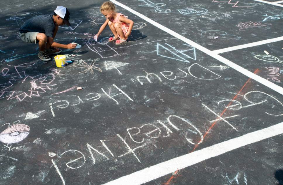 Rick Egan  |  The Salt Lake Tribune

Carter Searcy, 10 makes a chalk drawing with his sister, Elaine Searcy, 5, at the Millcreek Arts Festival at the Historic Baldwin Radio Factory, Friday, July 7, 2017.