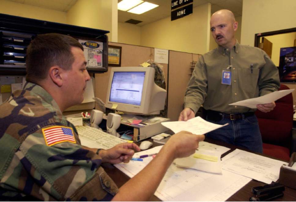 |  Tribune File Photo

SFC Layne Morris (right) receives his papers to return to Ft. Carson from SSG. Roland Knox at the Army national Guard Headquarters in Draper Monday April 19, 2004.