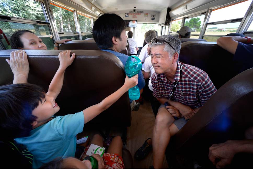 Scott Sommerdorf   |  The Salt Lake Tribune  
S.F. Bay Area resident Chris Hirano is spritzed with water by his cousin's son Kyle Augustus Tadashi Hirano, 5, during a hot bus trip from Delta, to the site of the Topaz Internment Camp, Saturday, July 8, 2017. The Hirano family planned a trip to bring 83 year-old Bobby Hirano back to the Topaz Internment Camp where he was held as a young boy, and to see the grand opening of the Topaz Museum.