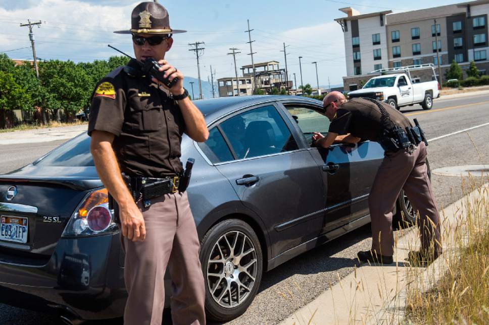 Chris Detrick  |  The Salt Lake Tribune
Utah Highway Patrol Lieutenant Beau Mason, left, and Corporal Mark Thompson talk to a driver who was pulled over for using his cellphone on Interstate 15 Thursday, July 13, 2017.
