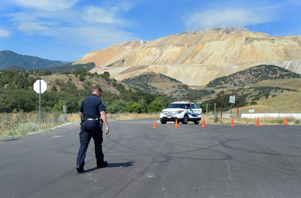 Scott Sommerdorf   |  The Salt Lake Tribune

A Unified Police officer mans the roadblock near the scene of a plane crash where two people in a small plane died. Access to the area was blocked by FAA as they investigate the scene off Bingham Canyon Road near Kennecott on Thursday, July 13, 2017.