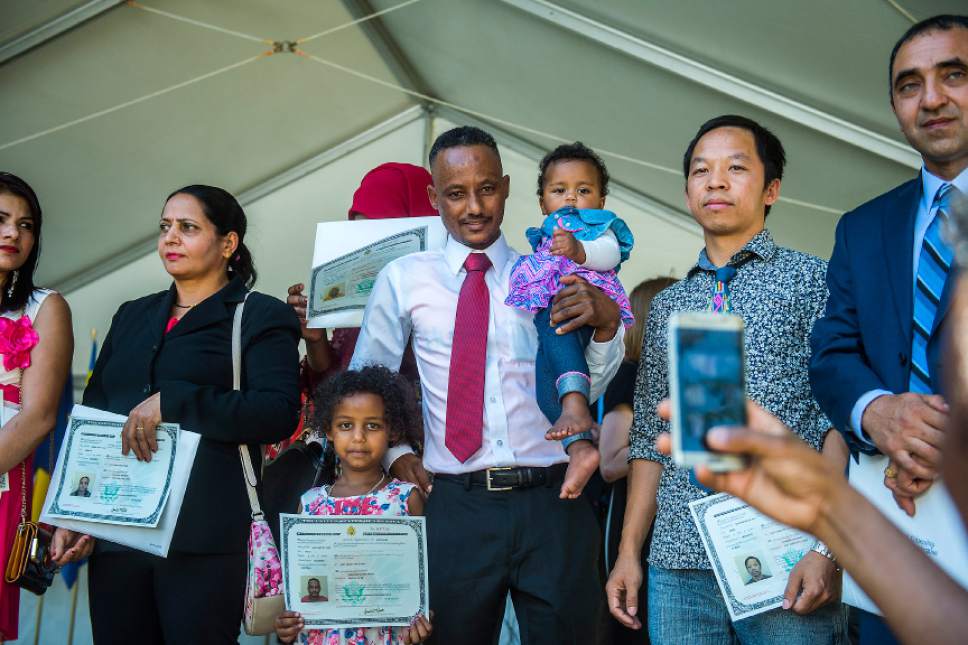 Chris Detrick  |  The Salt Lake Tribune

Abraham Hagos, 31, from Eritrea, poses for a picture with his daughters Kynte, 9 months, and Washington, 6, after becoming a citizen of United States of America during World Refugee Day at Liberty Park on Saturday, July 15, 2017.