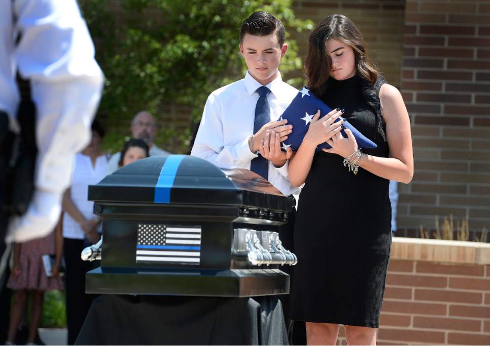 Scott Sommerdorf   |  The Salt Lake Tribune  
Talon and Aspen Reyes together hold the flag that was draping the casket of their family dog and K-9 partner for their father, Sgt. Chad Reyes at the memorial service for "Dingo," a Unified Police Department dog shot and killed in the line of duty July 6 while working with his K-9 handler Sgt. Chad Reyes, Saturday, July 15, 2017.