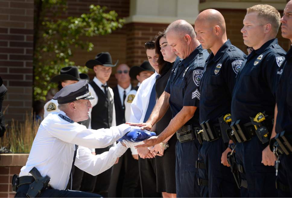 Scott Sommerdorf  |  The Salt Lake Tribune
Sgt. Chad Reyes accepts the flag that draped his K-9 partner's casket on Saturday from Sheriff Jim Winder at the memorial service for "Dingo," a Unified Police Department dog shot and killed in the line of duty July 6.