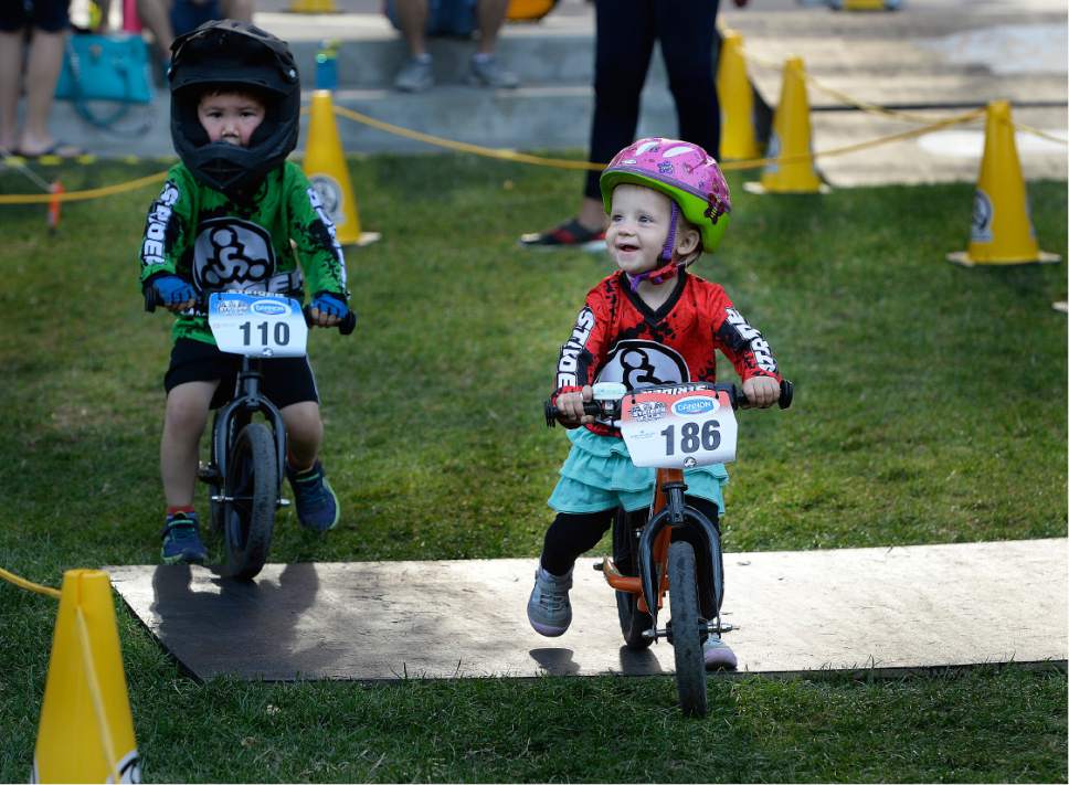 Scott Sommerdorf   |  The Salt Lake Tribune  
Two year old Ida Bergendorf, right, of Springville, beams up at her mother during open course warm up laps prior to the Strider World Championships, held at the Gallivan Center, Saturday, July 22, 2017.