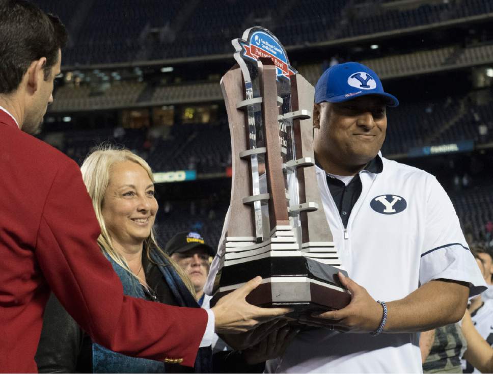 Rick Egan  |  The Salt Lake Tribune

Brigham Young Cougars head coach Kalani Sitake holds the trophy after BYU defeated Wyoming 24-21in the Poinsettia Bowl, at Qualcomm Stadium in San Diego, December 21, 2016.