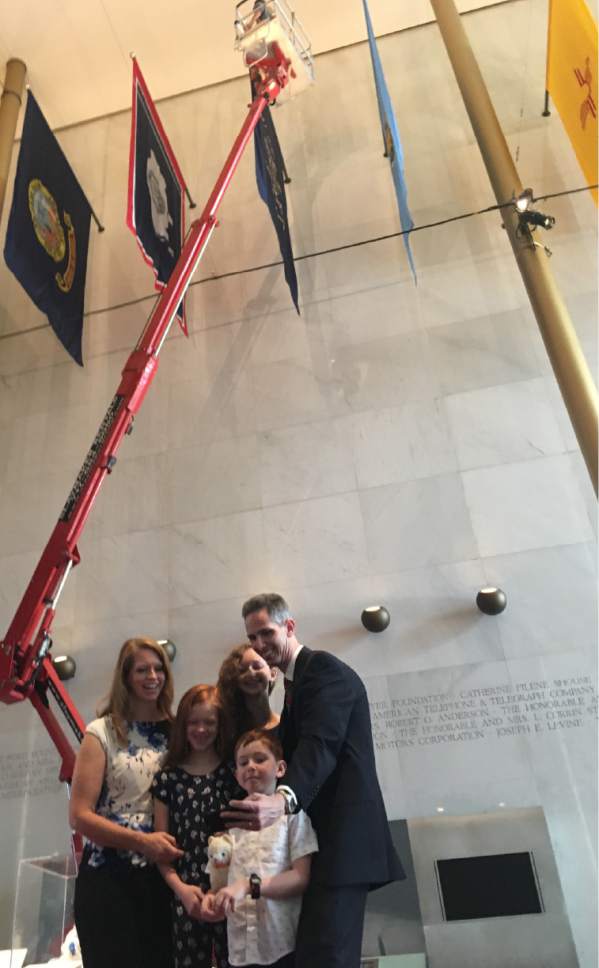 Thomas Burr  |  The Salt Lake Tribune

Holladay native Ryan Martin and his family take a selfie
photo at the Kennedy Center's Hall of States as workers prepare to replace an incorrect Utah state flag -- one that noted the arrival of the Mormon pioneers in 1647, not 1847 -- that had been hanging in the performing art center's Hall of States for some 15 years. Martin discovered the error and brought it to the Kennedy Center's attention.