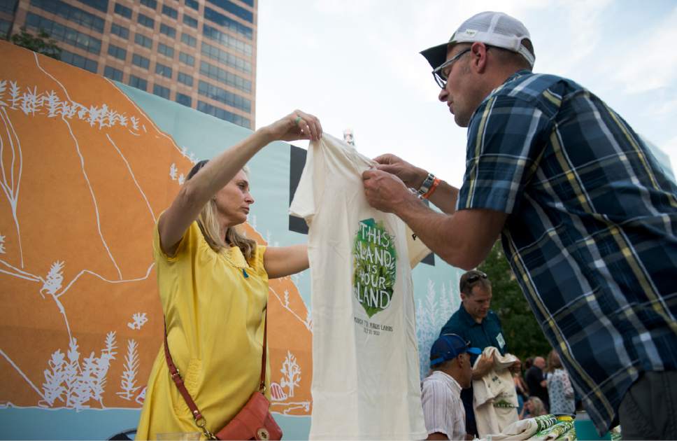 Leah Hogsten  |  The Salt Lake Tribune
Kyle MacDonald with Outdoors Empowered Network checks the size of a Outdoors Foundation t-shirt held by Jennifer Pringle during Tuesday's party at the Gallivan Center. Hundreds attending the 2017 Outsiders Ball party bid a fond farewell with a love letter to Utah's beautiful public lands, national parks, inspiring people, and unforgettable experiences. Outdoor Foundation's 5th Annual Outsiders Ball's mission is to encouraging young people to get outside and embark on their own adventures has never been more important. For the past 4 years, the Outdoor Foundation together with the outdoor community have helped raise $1.1 million to equip and empower the next generation of outdoor enthusiasts.