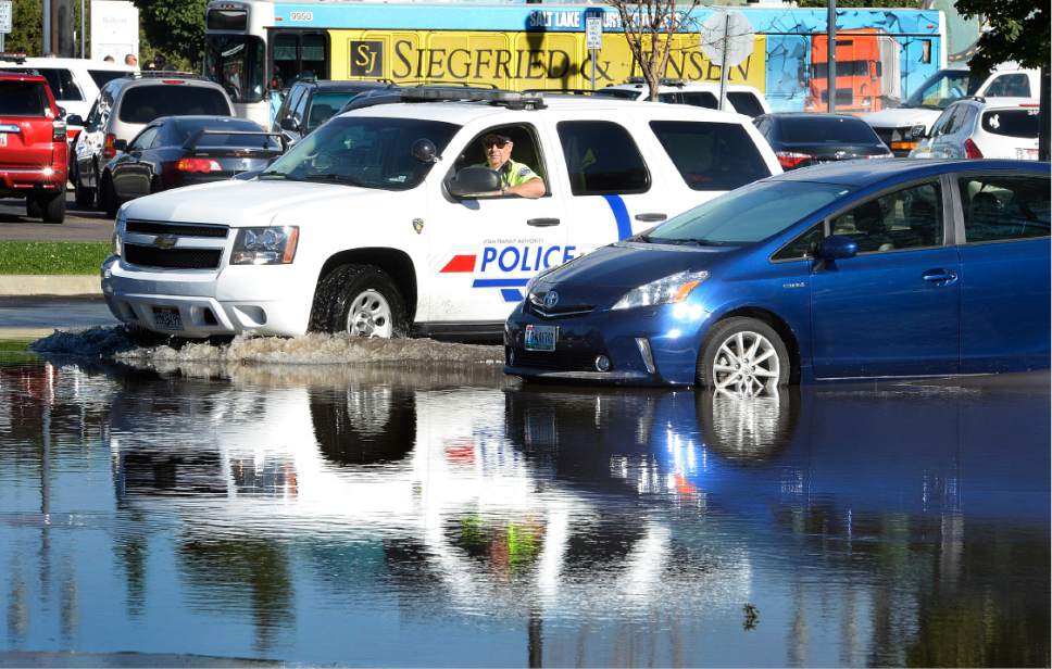 Scott Sommerdorf   |  The Salt Lake Tribune  
A Utah Transit Authority officer drives through the flooded parking lot at the Ballpark Station. Northbound Main Line TRAX trains were prevented from leaving the station due to flooding, Wednesday, July 26, 2017. Northbound riders were taken via a bus bridge to the next station.