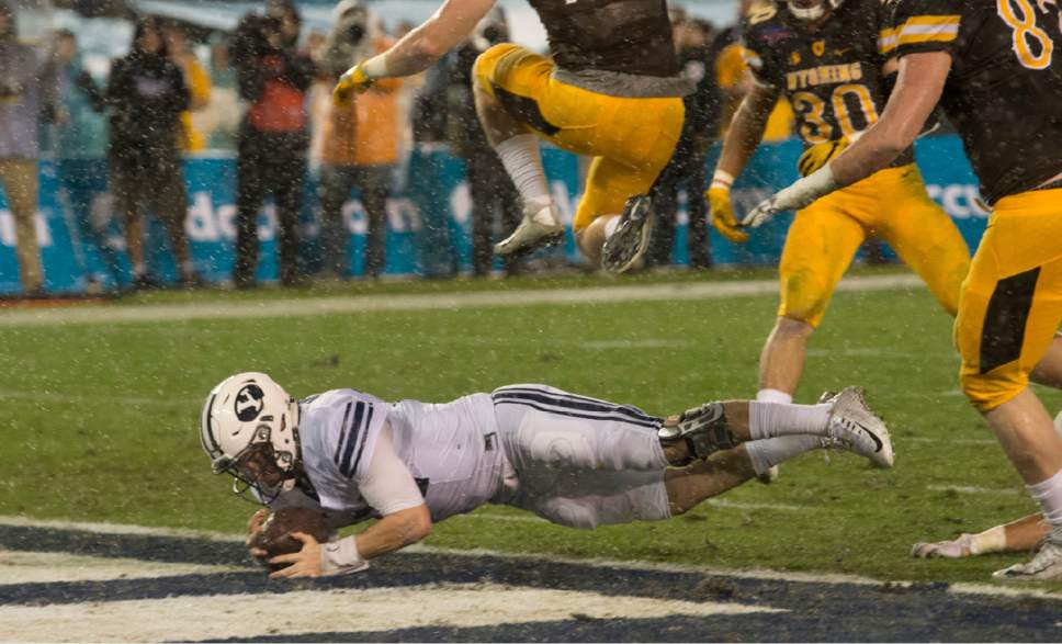 Rick Egan  |  The Salt Lake Tribune

Brigham Young quarterback Tanner Mangum (12) dives for the end zone for the first Cougar touchdown, in football action, Brigham Young Cougars vs. Wyoming Cowboys at Qualcomm Stadium in San Diego, December 21, 2016.